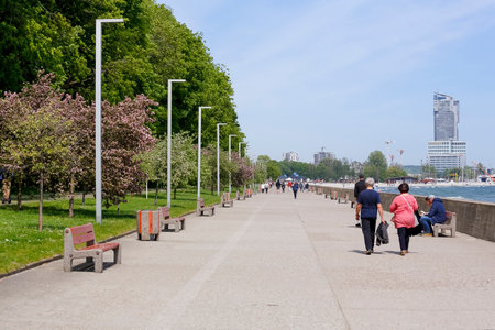 Gdynia, Poland - May 24, 2022: There are people walking along the promenade leading between Gulf of Gdansk and large trees.のeditorial素材
