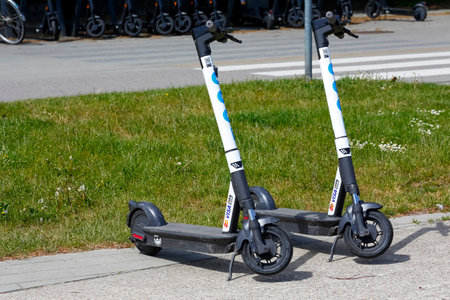 Gdynia, Poland - May 24, 2022: Electric scooters for rent were parked on the sidewalk. Electric scooters are now a popular means of transport.のeditorial素材