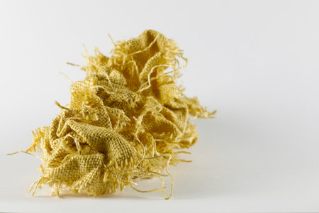 Pieces of synthetic fiber fabric have been crumpled and piled up, it looks like a wrinkled, shapeless and useless pile of fabricの写真素材