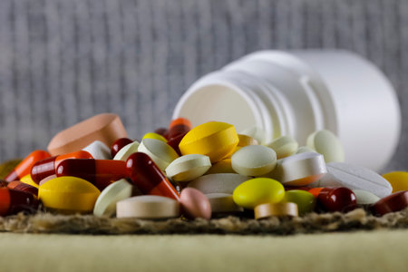 There is a large dose of various medicines, which can be seen against the background of a fabric fibers and overturned small bottlesの写真素材