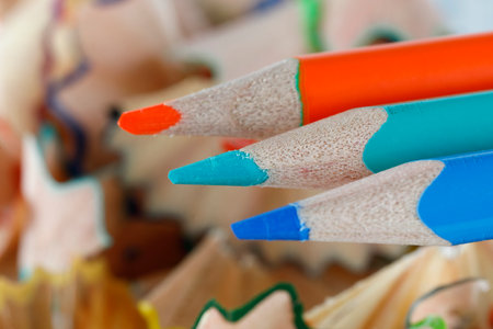 School supplies, three colored pencils on a background of shavings after sharpening themの写真素材