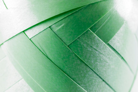 A roll of green ribbon for gift wrapping with a visible way of winding its successive layers. This reel is shown close up and provides a background to be used for various purposesの写真素材