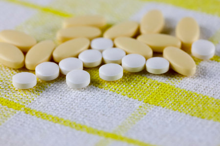 The pills lie on a white napkin with a yellow checkered patternの写真素材