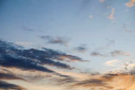 A sky with some clouds formed above the slowly setting sunの写真素材