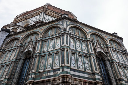An architectural fragment of the majestic building of the Cathedral of Santa Maria Del Fiore, which is an undisputed masterpiece of sacred architecture on a global scale. Florence, Italy.の写真素材
