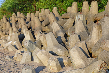Reinforced multi-arm concrete blocks protecting dunes from the damaging effects of sea waves on the Baltic Sea coast in Ustronie Morskie, West Pomerania, Poland.の写真素材