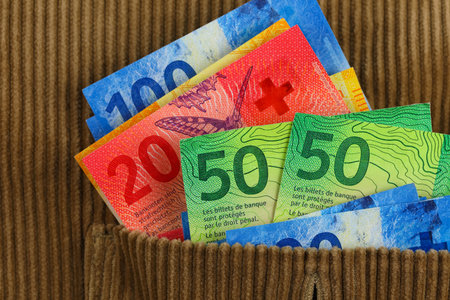 Banknotes sticking out of the pocket of a corduroy sweatshirt. This theme can be used to illustrate a wide range of financial topics. Swiss franc currency, CHFの写真素材