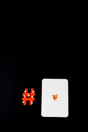 Social media symbol Hashtag in orange color, with a community of miniature people seating on a...