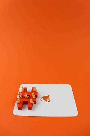 Hashtag digital symbol in orange color with a miniature people on it, and on a orange America map....