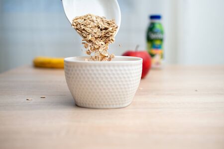 Healthy breakfast cereal pouring on the tableの写真素材