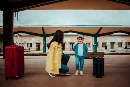 Mother and child with mask waiting a train on public train stationの写真素材