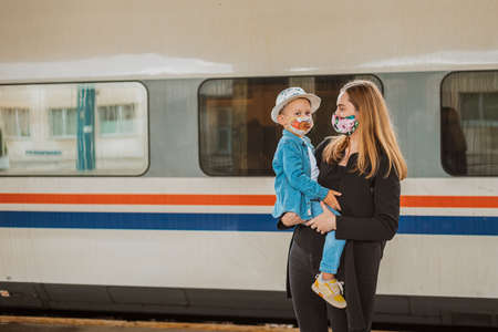 Mother and child with face mask and luggage bags, ready to travelの写真素材