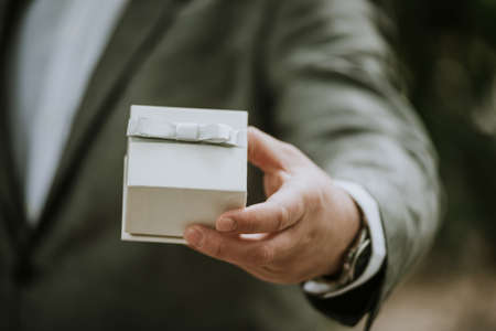 man giving a present in a gift box close upの写真素材