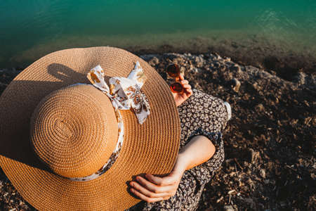 woman with summer hat looking at the  lakeの写真素材