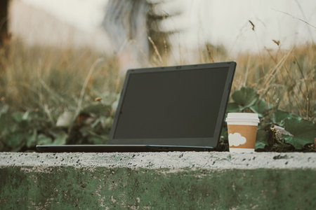laptop outdoor , with coffee cup, remote location in nature