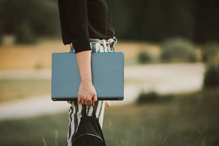 woman holding laptop outdoors in natureの写真素材
