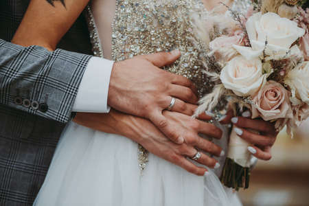 wedding couple holding hands with bouquetの写真素材