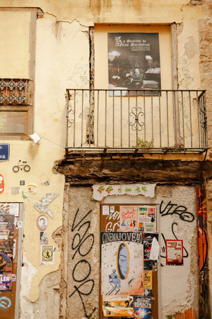 Urban street scene with weathered buildings, graffiti, posters, and a balcony creating a gritty, artistic city vibeの写真素材