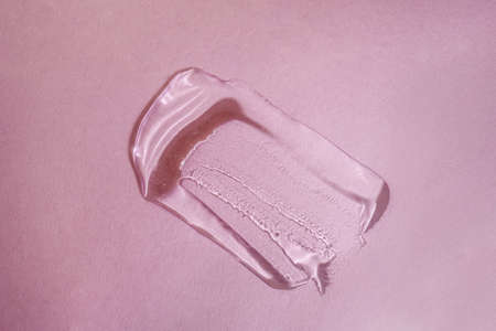 A drop of transparent cosmetic gel on a pink backgroundの写真素材