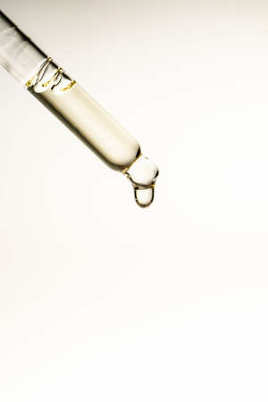 A drop of cosmetic oil falls from the pipetteの写真素材