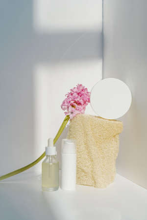 Cream, serum and natural loofah sponge on a light background.の写真素材