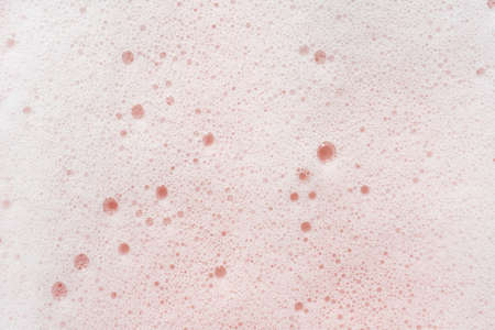 The texture of soap foam with bubbles on a pink background.の写真素材