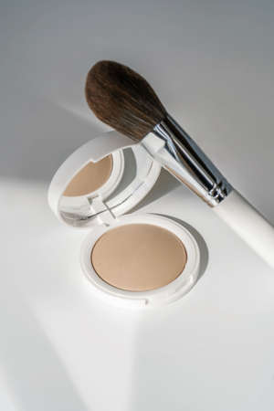 Powder and cosmetic brush on a white background.の写真素材