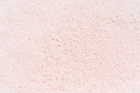 The texture of soap foam with bubbles on a pink background.の写真素材