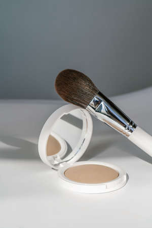 Powder and cosmetic brush on a white background.の写真素材