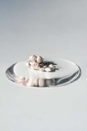 A drop of cosmetic gel with flower on a white background.