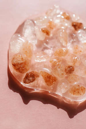 Himalayan salt stones on a pink background in bright sunlight in the water. Top view.の写真素材