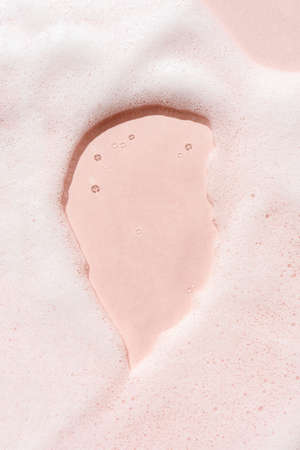 The texture of soap foam with bubbles on a pink background.の写真素材
