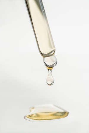 A drop of cosmetic oil falls from the pipetteの写真素材