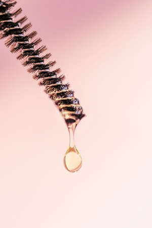 A drop of oil for eyebrows and eyelashes falls from the brushの写真素材