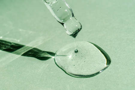 A drop of cosmetic oil falls from the pipette