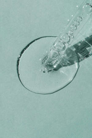 A cosmetic product flows out of a pipette with bubbles.の写真素材