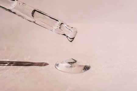 A drop of cosmetic oil falls from the pipette