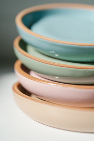 A large stack of ceramic cups in pastel colors.の写真素材
