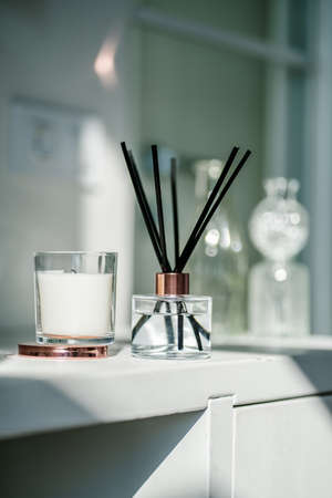 An aromatic reed diffuser stands on a table against a blurry background.の写真素材