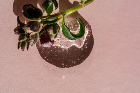 Transparent cosmetic gel on a pink background.
