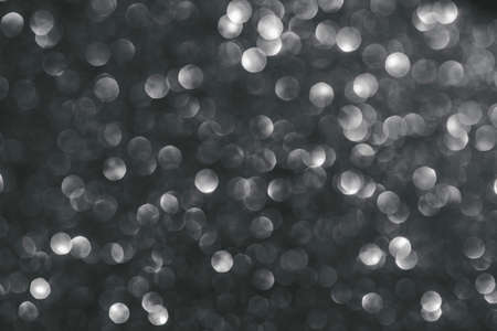 Black abstract glitter background with shiny bokeh