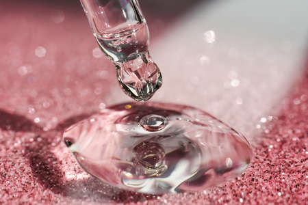 Cosmetic pipette with a pink on dark background.の写真素材