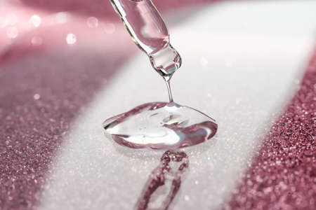Cosmetic pipette with a pink on dark background.の写真素材