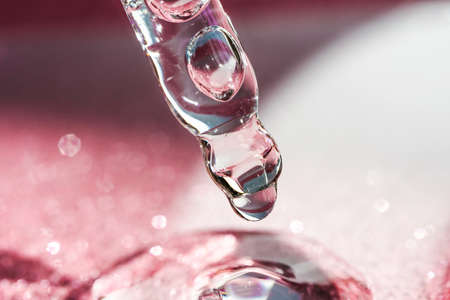 Cosmetic pipette with a pink on dark background.の写真素材