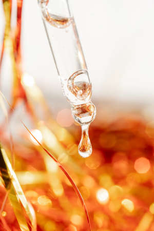 Pipette with gel on the background of tinsel.の写真素材