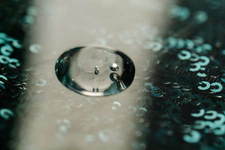 The texture of the serum or oil on an emerald background.