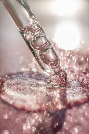 The texture of the serum or oil on an emerald background.