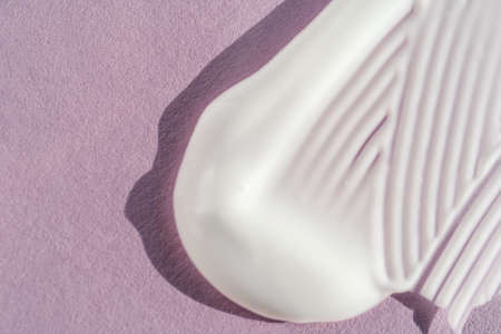 The texture of the white cream on a purple background.の写真素材