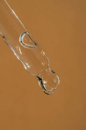 Pipette with cosmetics on a beige background.の写真素材