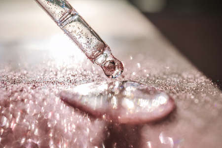 The texture of the serum or oil on an emerald background.の写真素材